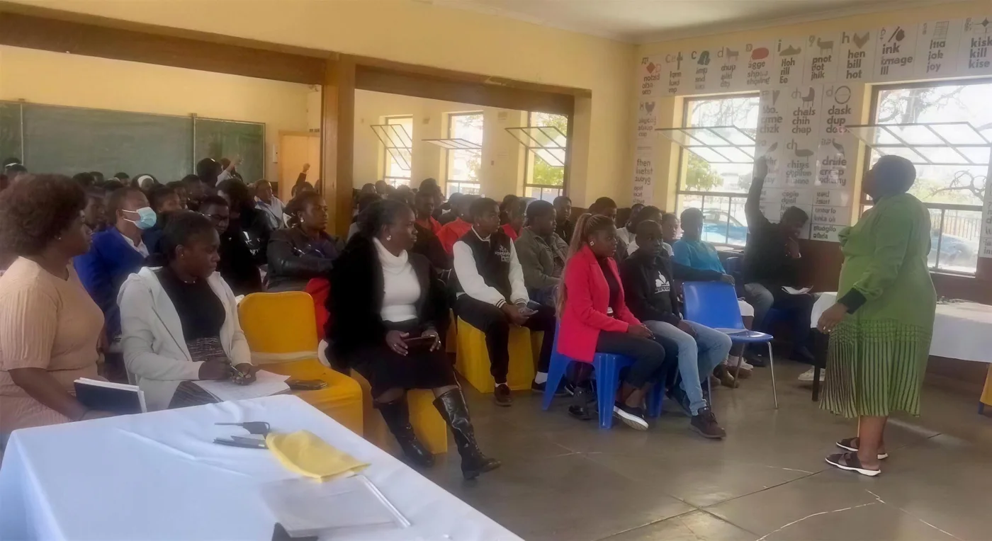 A hall filled with foundation phase educators at a Read Today SA training session, with a facilitator presenting beside phonics charts on the wall